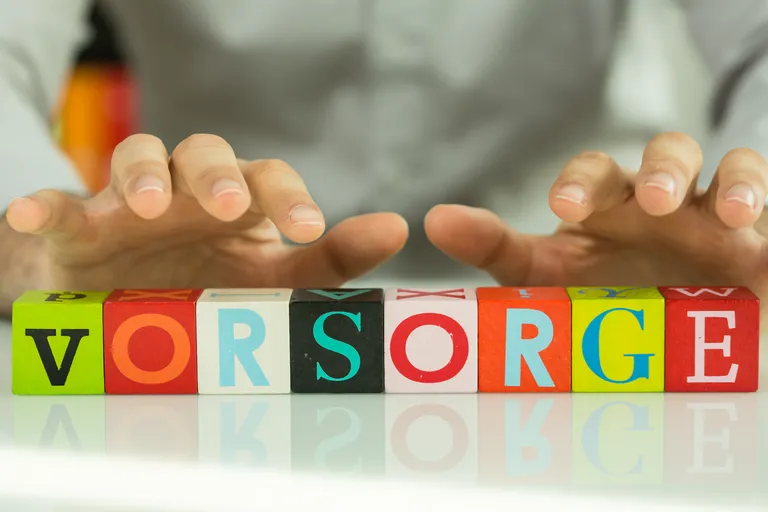 Colourful wooden building blocks on which the word provision is written in German.