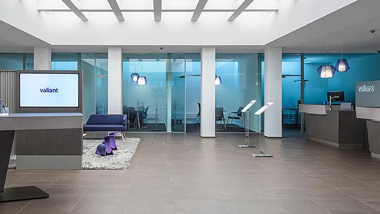 Reception room at Bank Valiant grey tiled floor screens a purple armchair.