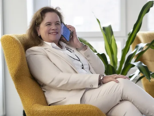 Esther Himmel, an employee of Bosshard & Partner, sits in an armchair and talks on the phone.