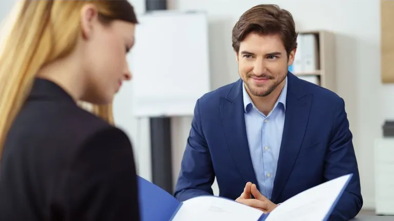 Woman and man in a conversation. The man is wearing a suit and looking at the woman, the woman is looking at something in front of her.