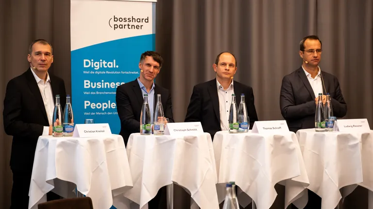 Speakers at the 2023 keynote event stand next to each other at high tables.